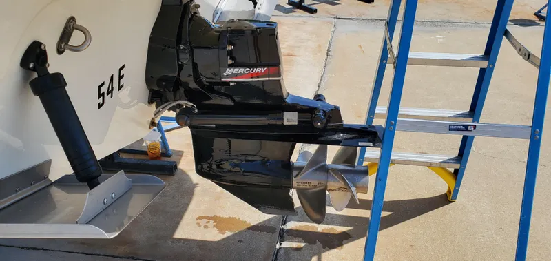 Slide: The Image of 2003 Wellcraft 2400 Martinique boat with Mercury outboard motor and ladder on concrete surface. - 5