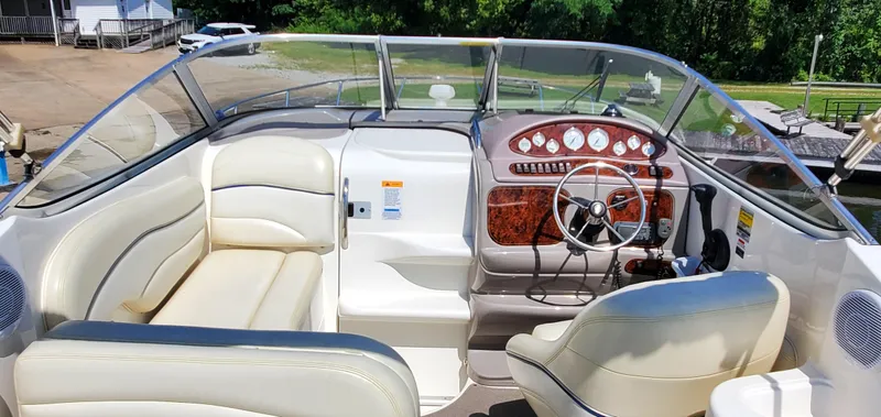 Slide: The Image of 2003 Wellcraft 2400 Martinique boat interior with beige seating and wood-accented dashboard. - 8