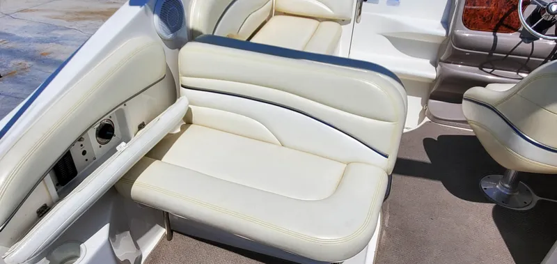 Slide: The Image of 2003 Wellcraft 2400 Martinique boat interior with white leather seating and steering area. - 9