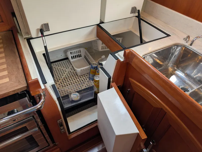 Slide: The Image of Luxurious wooden interior of a 2015 Outbound 46 yacht kitchen with stove and cabinets. - 7
