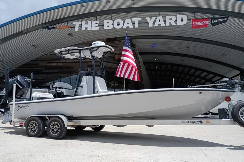 Slide: The Image of 2025 Yellowfin 24 CE boat on trailer at The Boat Yard, American flag displayed. - 1
