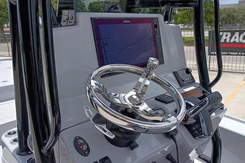 Slide: The Image of 2025 Yellowfin 24 CE boat helm with chrome steering wheel and Simrad display. - 13