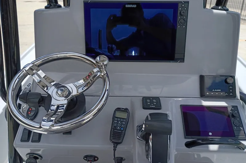 Slide: The Image of 2025 Yellowfin 24 CE boat dashboard with steering wheel, Simrad display, and control panel. - 17