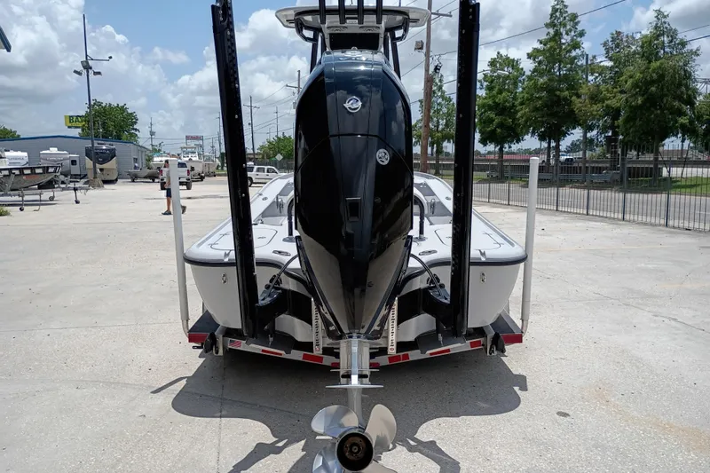 Slide: The Image of 2025 Yellowfin 24 CE boat on trailer, rear view with outboard motor, in a dealership lot. - 3