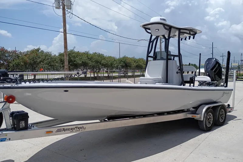 Slide: The Image of 2025 Yellowfin 24 CE boat on trailer, parked outdoors under a cloudy sky. - 6