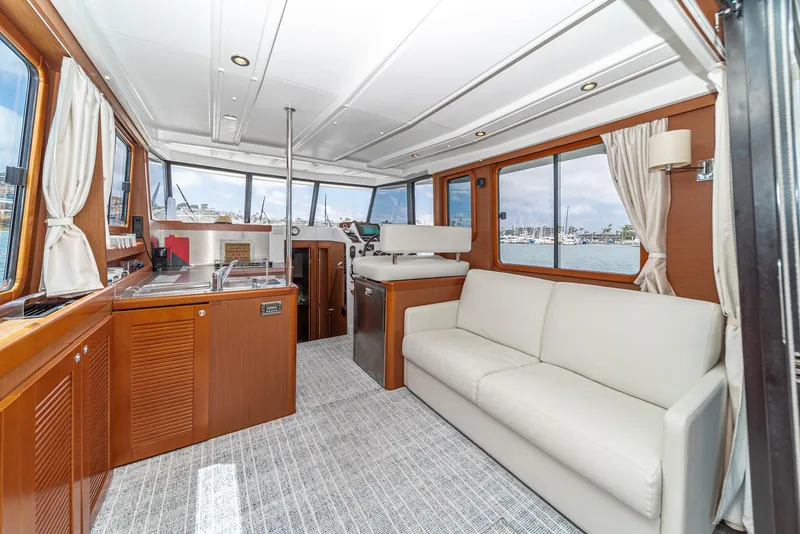 Slide: The Image of Interior of 2014 Beneteau Swift Trawler 34 with modern furnishings and panoramic windows. - 13