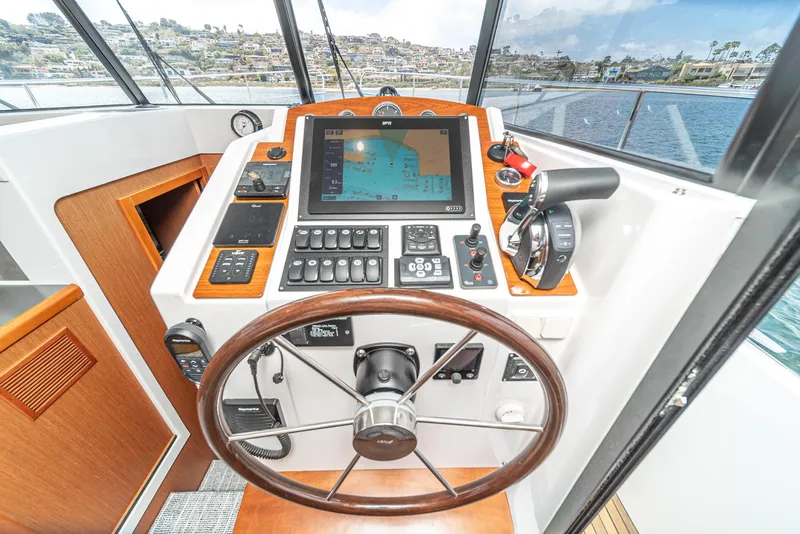 Slide: The Image of Helm of 2014 Beneteau Swift Trawler 34 with navigation controls and steering wheel. - 14