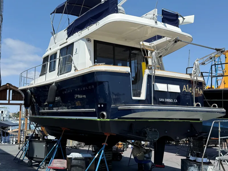 Slide: The Image of 2014 Beneteau Swift Trawler 34 in dry dock, San Diego, blue hull, maintenance work. - 24
