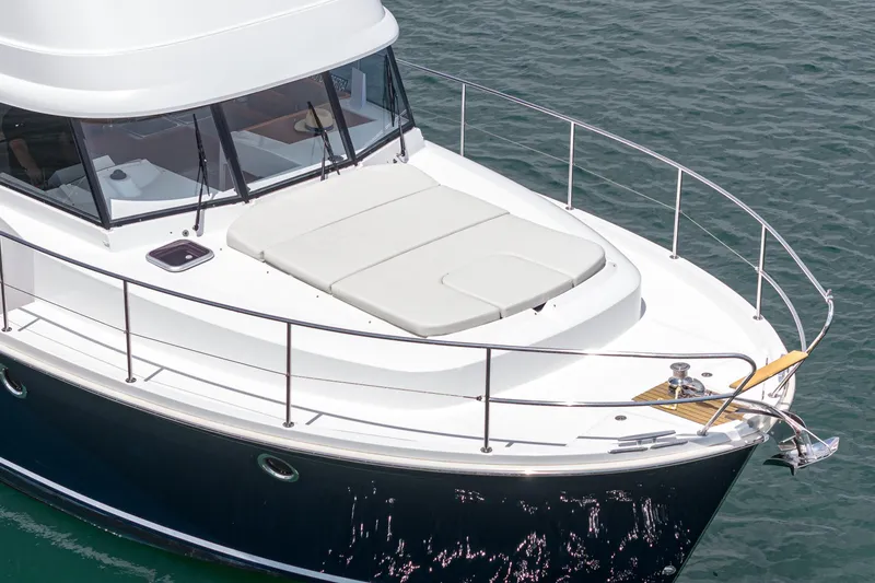 Slide: The Image of 2014 Beneteau Swift Trawler 34, white deck, sleek design, on calm water. - 4