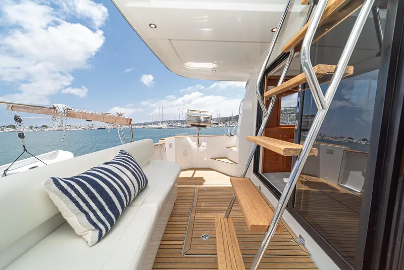 Slide: The Image of 2014 Beneteau Swift Trawler 34 deck with seating, ladder, and ocean view. - 9