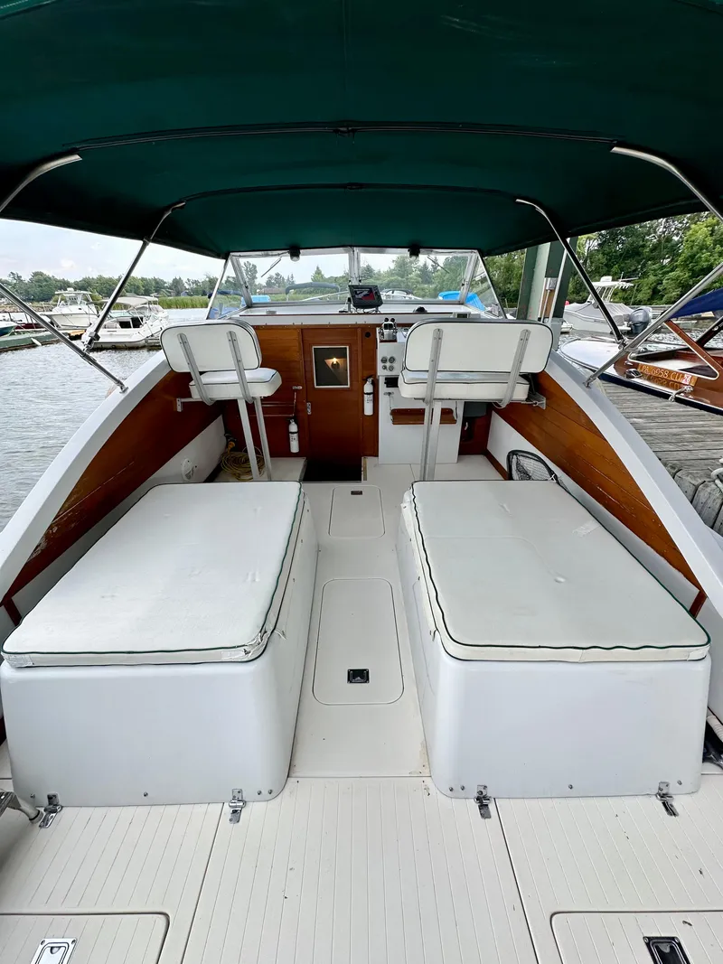 Slide: The Image of 1966 Bertram 31 Bahia Mar boat interior with seating and helm, docked at marina. - 5