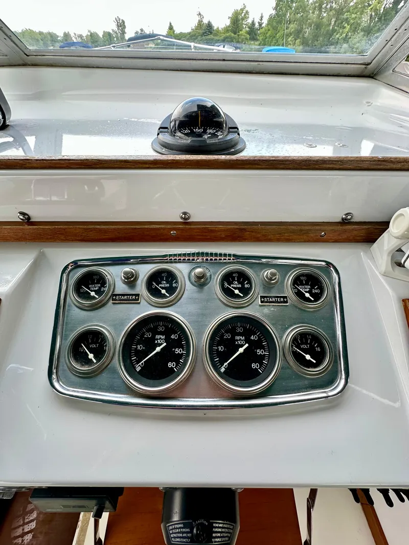 Slide: The Image of 1966 Bertram 31 Bahia Mar dashboard with gauges and compass, showcasing vintage boat controls. - 7