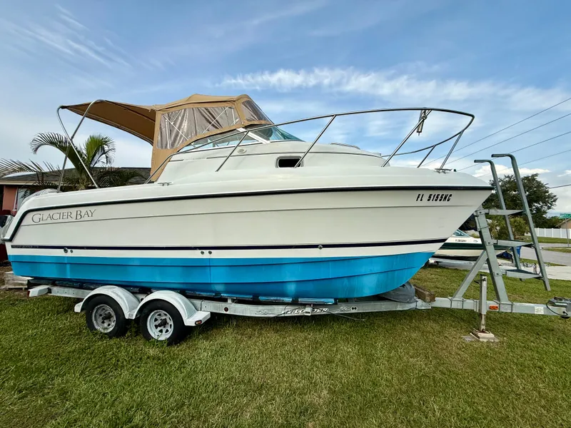 The Image of 2002 Glacier Bay 2670 Island Runner boat on trailer, parked on grass. - 1
