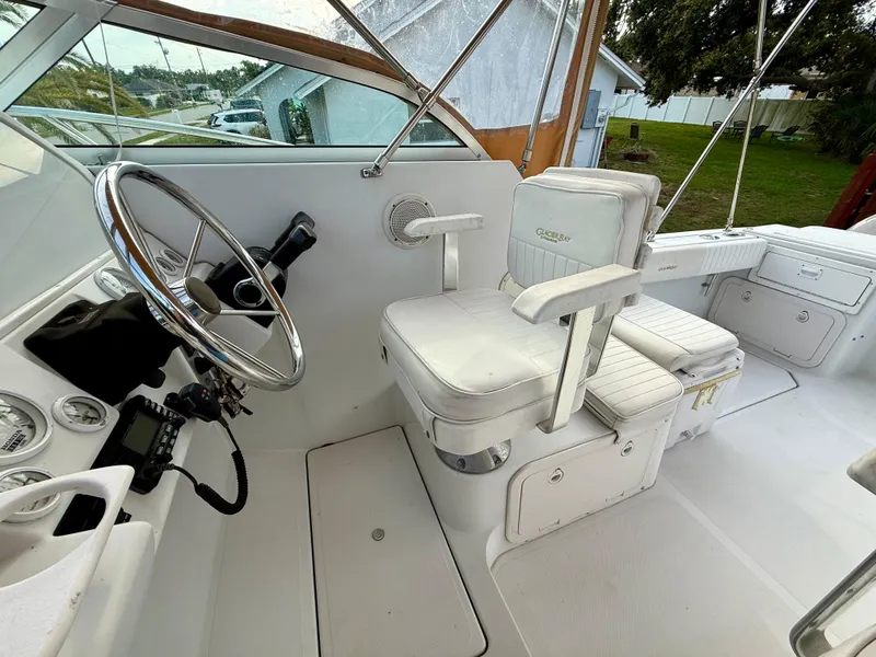 Slide: The Image of 2002 Glacier Bay 2670 Island Runner helm with steering wheel and white captain's chair. - 11