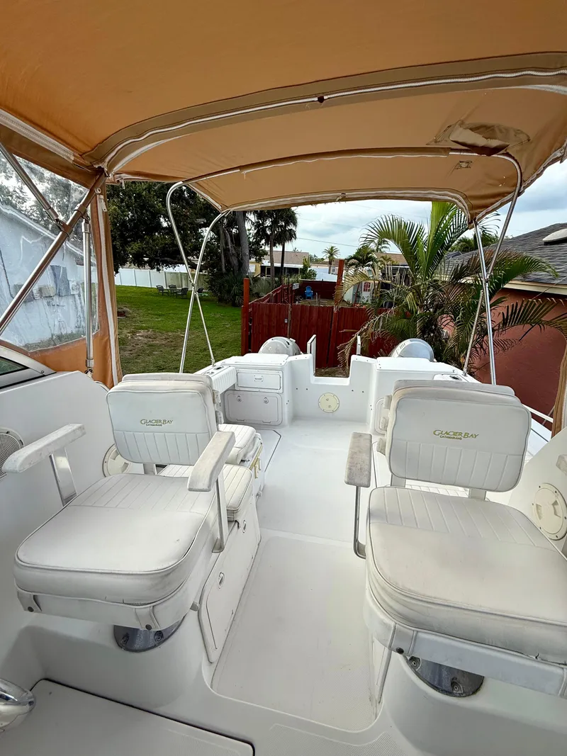 Slide: The Image of 2002 Glacier Bay 2670 Island Runner boat interior with white seating and canopy. - 13