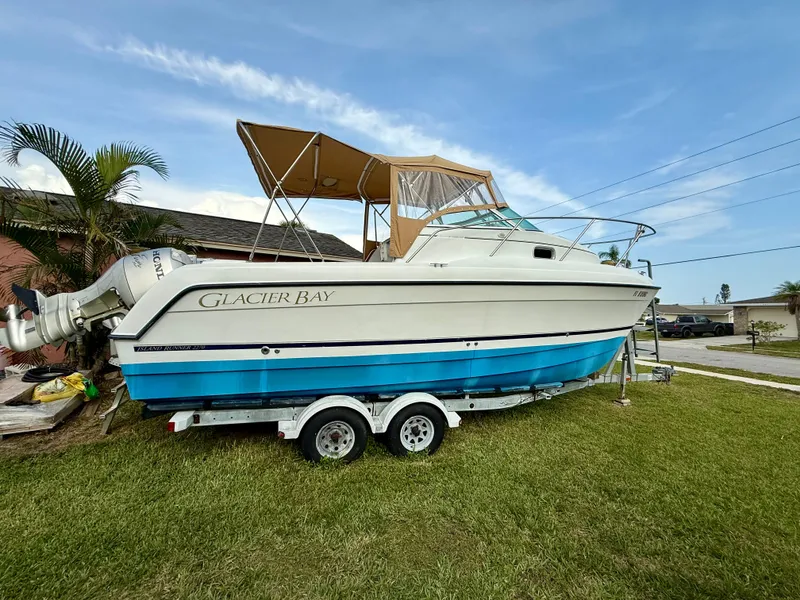 Slide: The Image of 2002 Glacier Bay 2670 Island Runner boat on trailer, parked on grass. - 3