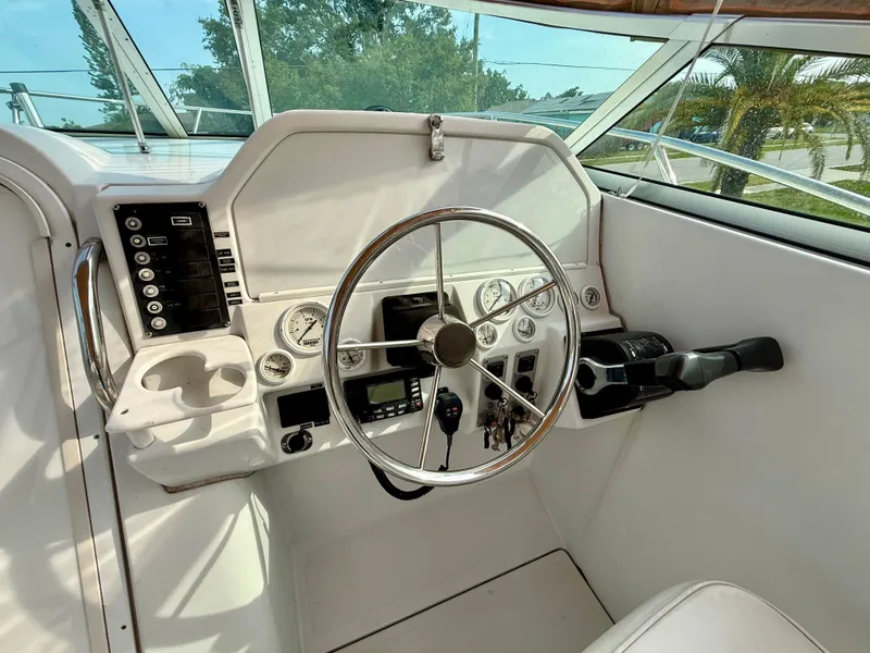 Slide: The Image of 2002 Glacier Bay 2670 Island Runner helm with steering wheel and control panel. - 7