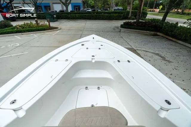 Slide: The Image of 2024 Sea Pro 208 Bay boat, white deck, parked in a lot with greenery. - 18