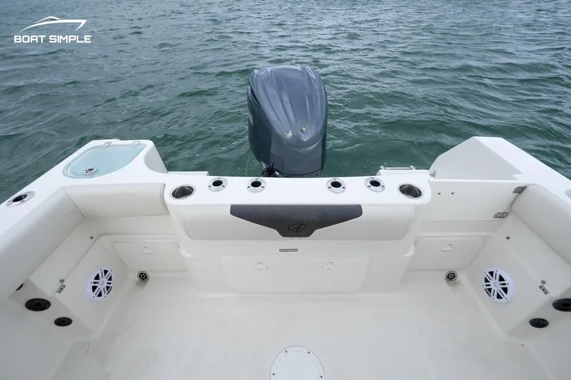 Slide: The Image of 2024 Sailfish 242 CC boat deck with motor, featuring rod holders and storage. - 5