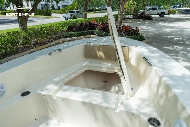 Slide: The Image of 2024 Scout 195 Sportfish boat interior with open storage compartment, parked outdoors. - 9