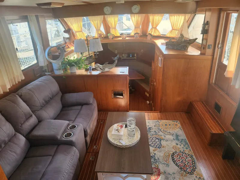 Slide: The Image of Cozy 1987 Kha Shing 38 yacht interior with plush seating, wooden decor, and nautical accents. - 3