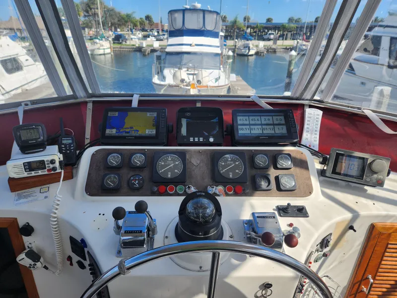 Slide: The Image of Cockpit of 1987 Kha Shing 38 yacht with navigation instruments and marina view. - 4