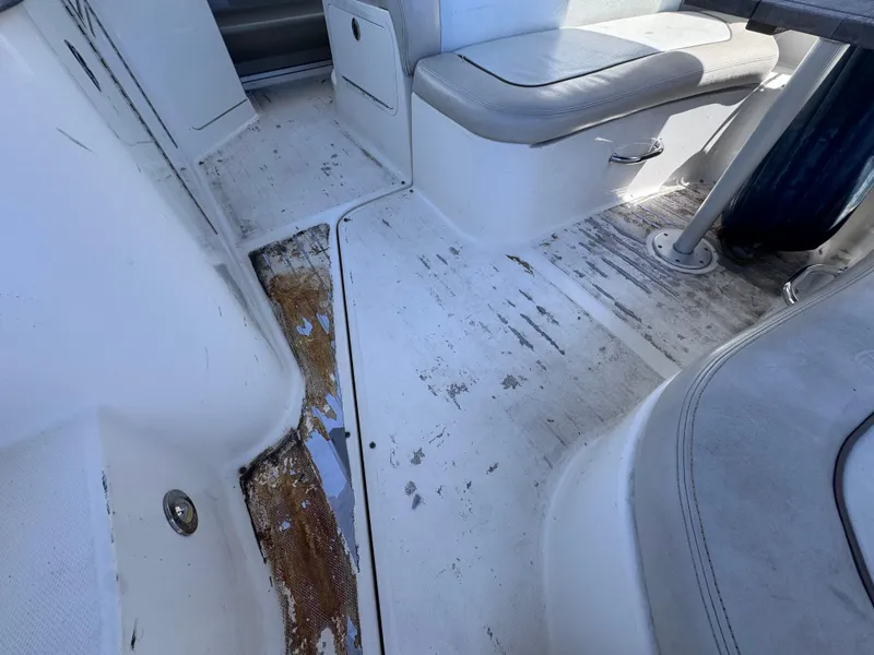 Slide: The Image of 2012 Sea Ray 330 Sundancer interior with worn flooring and seating area. - 14
