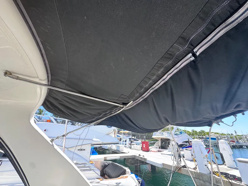 Slide: The Image of 2012 Sea Ray 330 Sundancer with black canopy at marina dock. - 17