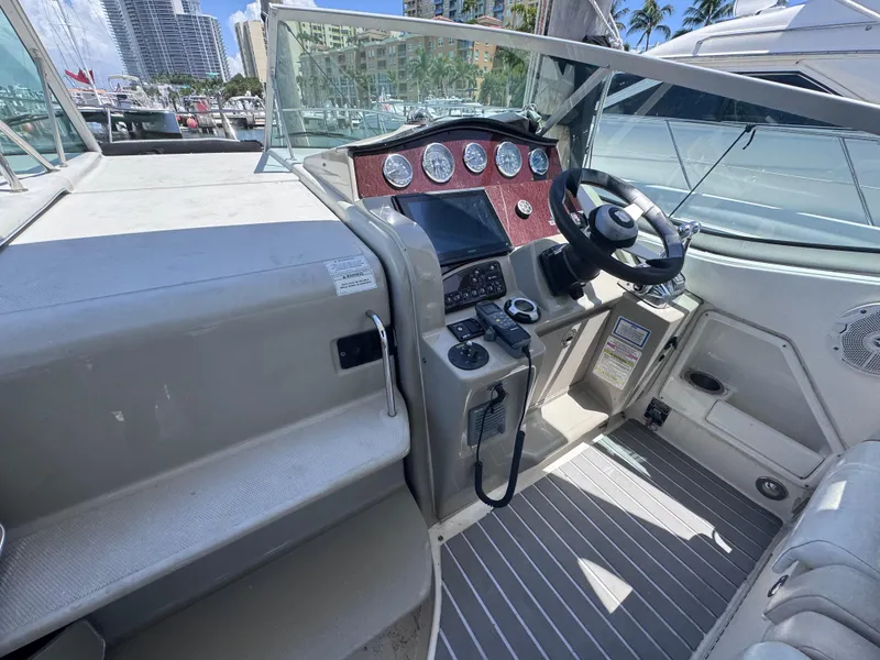 Slide: The Image of 2012 Sea Ray 330 Sundancer helm with modern controls and cityscape background. - 18
