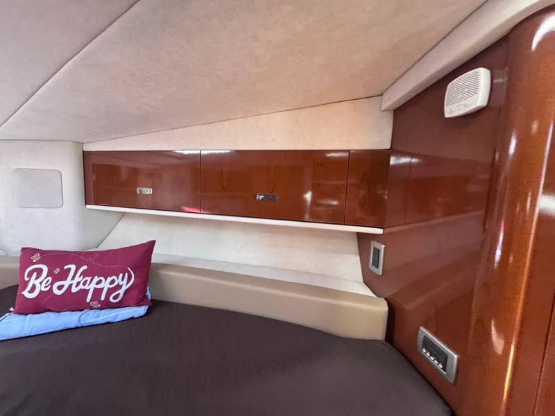 Slide: The Image of Cabin interior of 2012 Sea Ray 330 Sundancer with wooden cabinets and "Be Happy" pillow. - 33