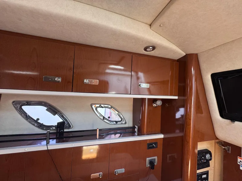 Slide: The Image of Interior of 2012 Sea Ray 330 Sundancer with wooden cabinets and porthole windows. - 35