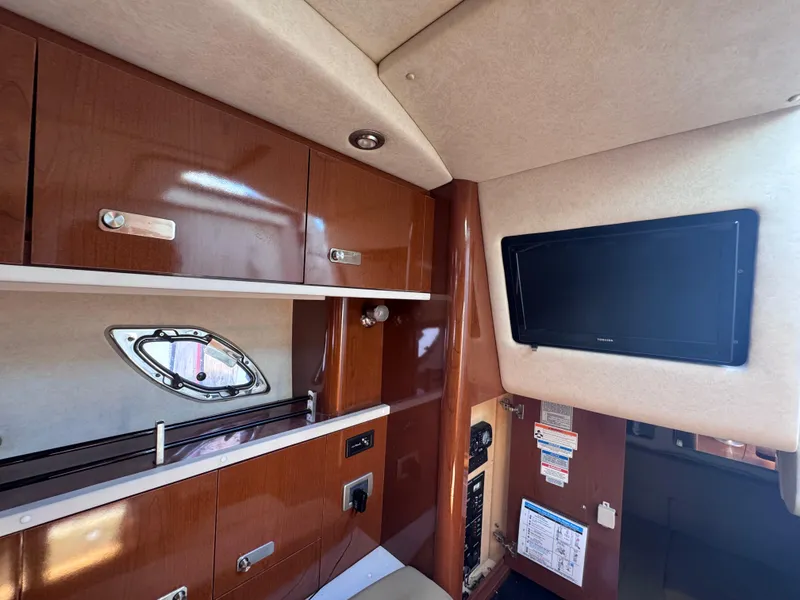 Slide: The Image of Interior of 2012 Sea Ray 330 Sundancer with wood cabinets and wall-mounted TV. - 36