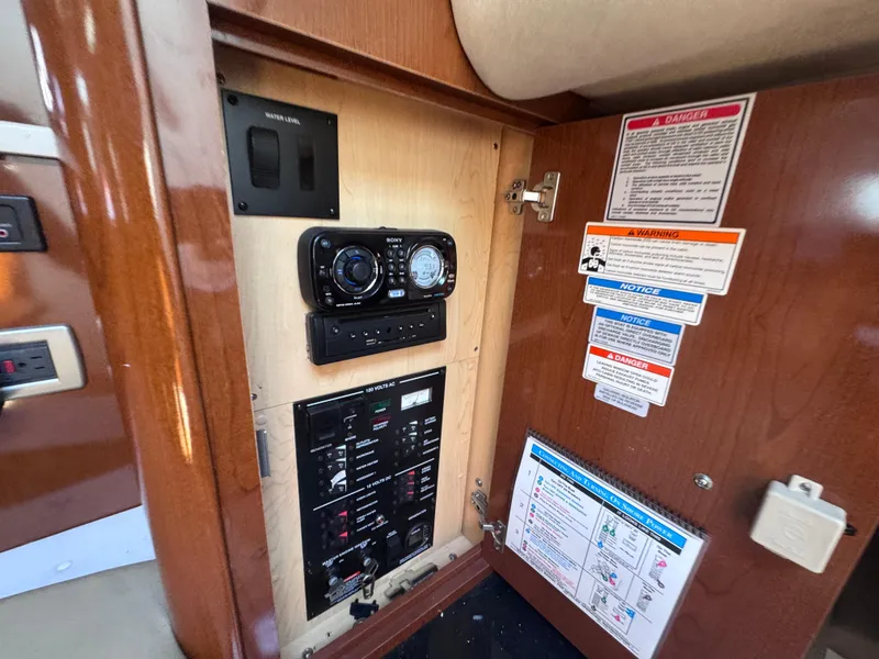 Slide: The Image of Control panel inside 2012 Sea Ray 330 Sundancer boat, featuring gauges and warning labels. - 38