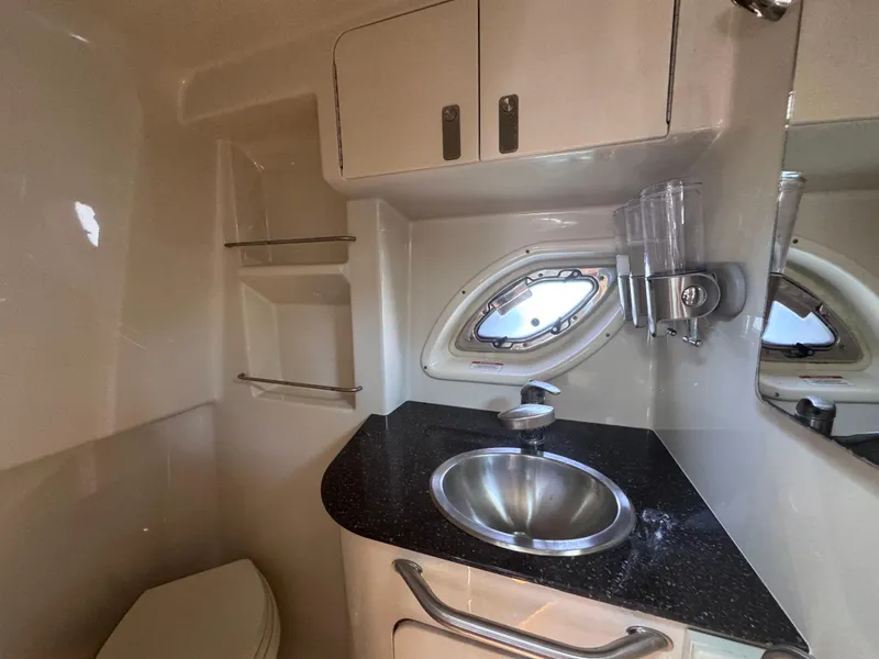Slide: The Image of 2012 Sea Ray 330 Sundancer bathroom with sink, porthole, and storage cabinets. - 43