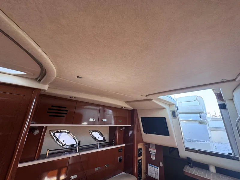 Slide: The Image of Interior of 2012 Sea Ray 330 Sundancer yacht with wood cabinetry and porthole windows. - 45