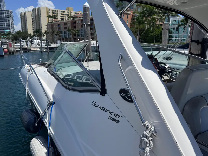 Slide: The Image of 2012 Sea Ray 330 Sundancer docked at marina with cityscape background. - 9