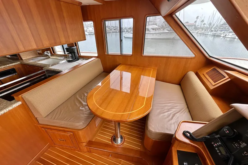 Slide: The Image of Luxurious 2006 Grand Banks 72 Yachtfisher interior with wooden dining area and marina view. - 20
