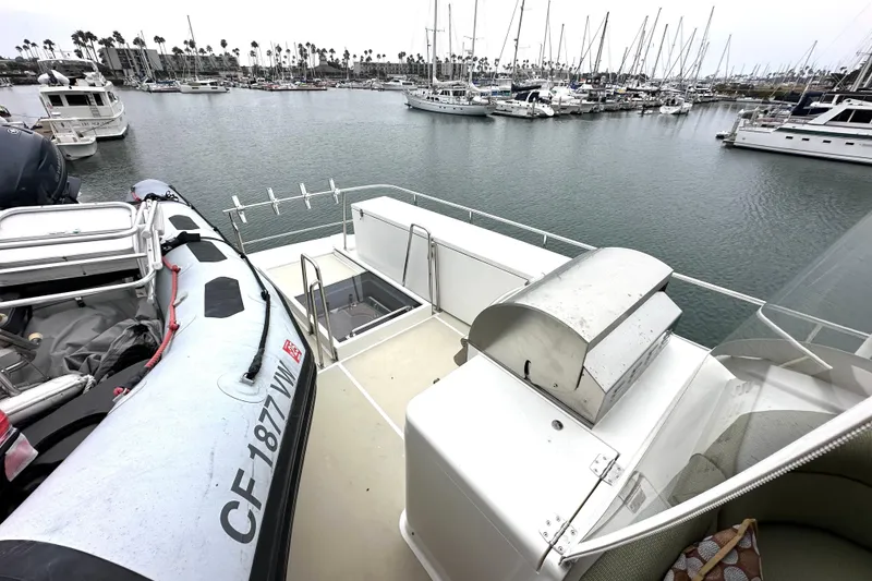 Slide: The Image of 2006 Grand Banks 72 Yachtfisher with dinghy and grill, docked in a marina. - 31
