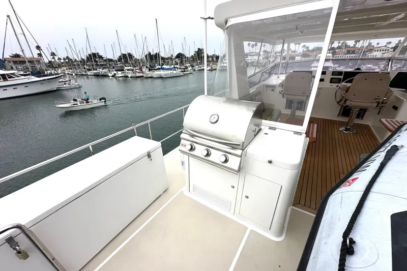 Slide: The Image of 2006 Grand Banks 72 Yachtfisher with outdoor grill, docked in marina with sailboats. - 32