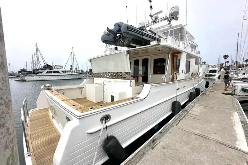 Slide: The Image of 2006 Grand Banks 72 Yachtfisher docked at marina, showcasing elegant design and spacious deck. - 4