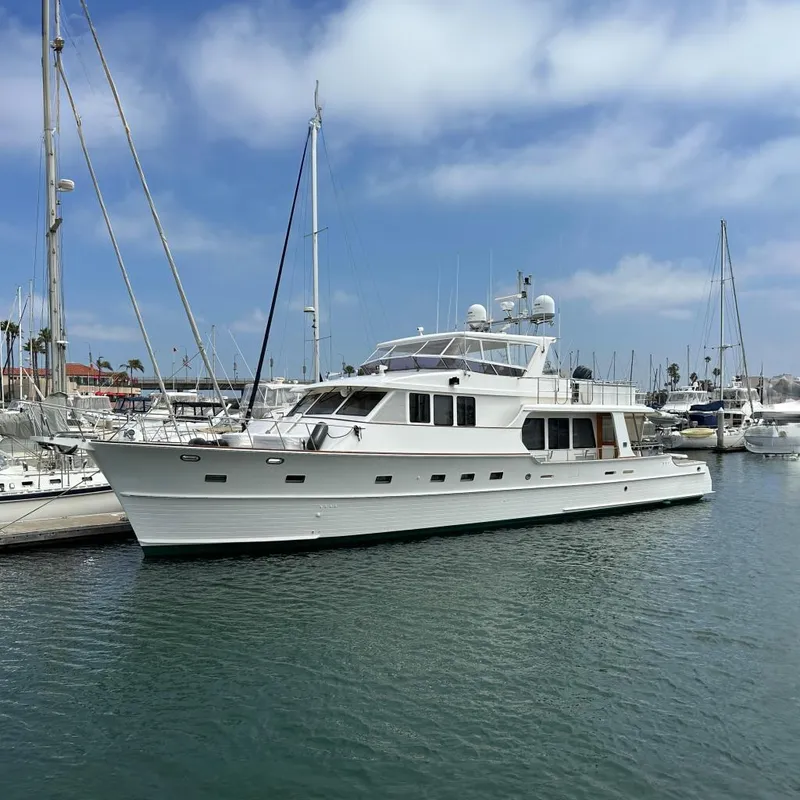Slide: The Image of 2006 Grand Banks 72 Yachtfisher docked in a marina under a clear blue sky. - 3