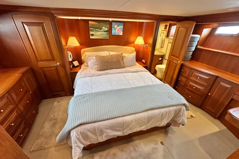 Slide: The Image of Luxurious bedroom in 2006 Grand Banks 72 Yachtfisher with elegant wood furnishings. - 42