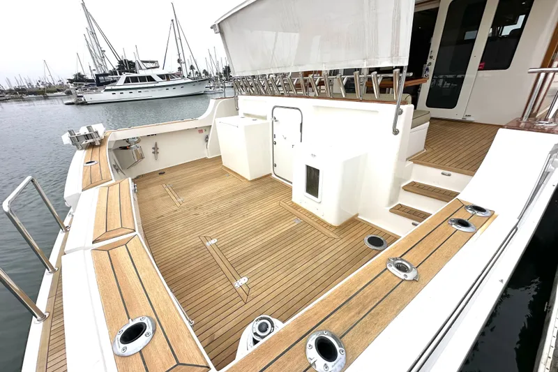 Slide: The Image of 2006 Grand Banks 72 Yachtfisher with spacious teak deck and marina view. - 8