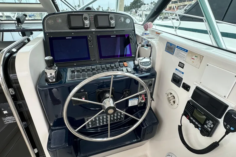 Slide: The Image of 2007 Tiara Yachts 3600 helm with dual Simrad displays and navigation controls. - 10