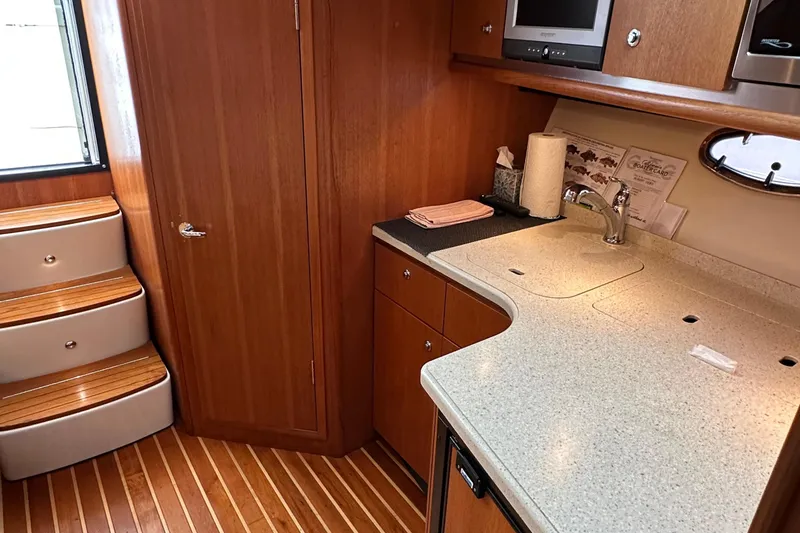 Slide: The Image of 2007 Tiara Yachts 3600 interior with wooden cabinetry and modern kitchenette. - 18