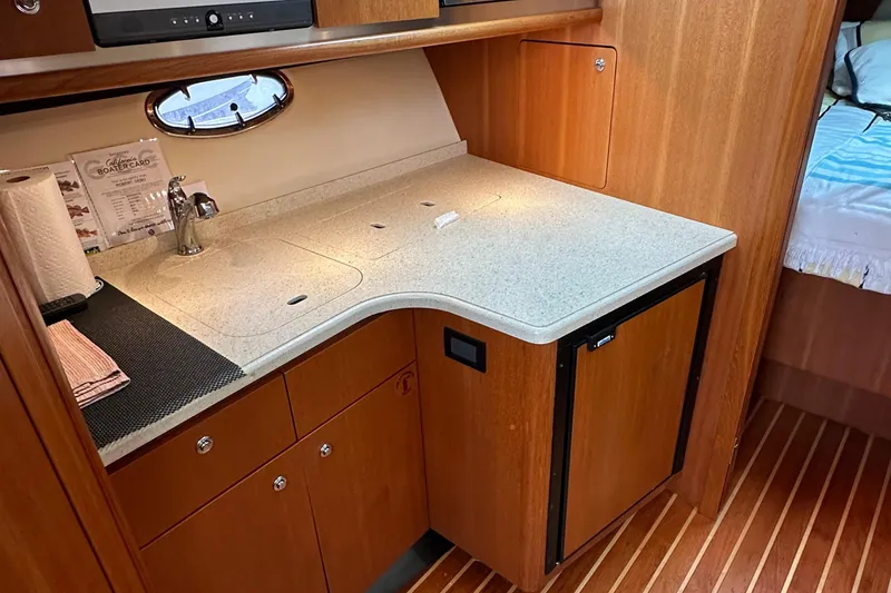 Slide: The Image of 2007 Tiara Yachts 3600 interior galley with sink, countertop, and wooden cabinetry. - 19