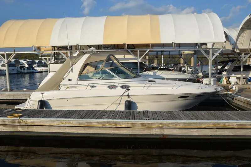 The Image of 2001 Sea Ray 310 Sundancer docked at marina under canopy, sunny day. - 1