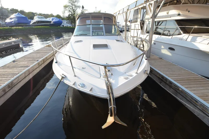Slide: The Image of 2001 Sea Ray 310 Sundancer docked at marina, showcasing sleek design and spacious deck. - 11