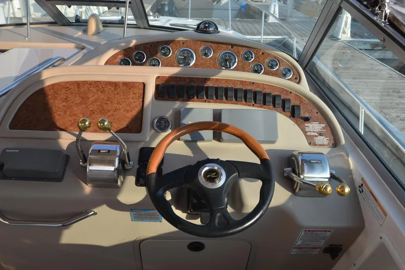 Slide: The Image of Cockpit of 2001 Sea Ray 310 Sundancer with steering wheel and control panel. - 13