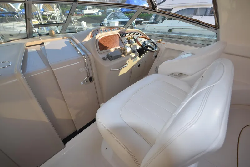 Slide: The Image of Interior cockpit of 2001 Sea Ray 310 Sundancer with white leather seating and control panel. - 14